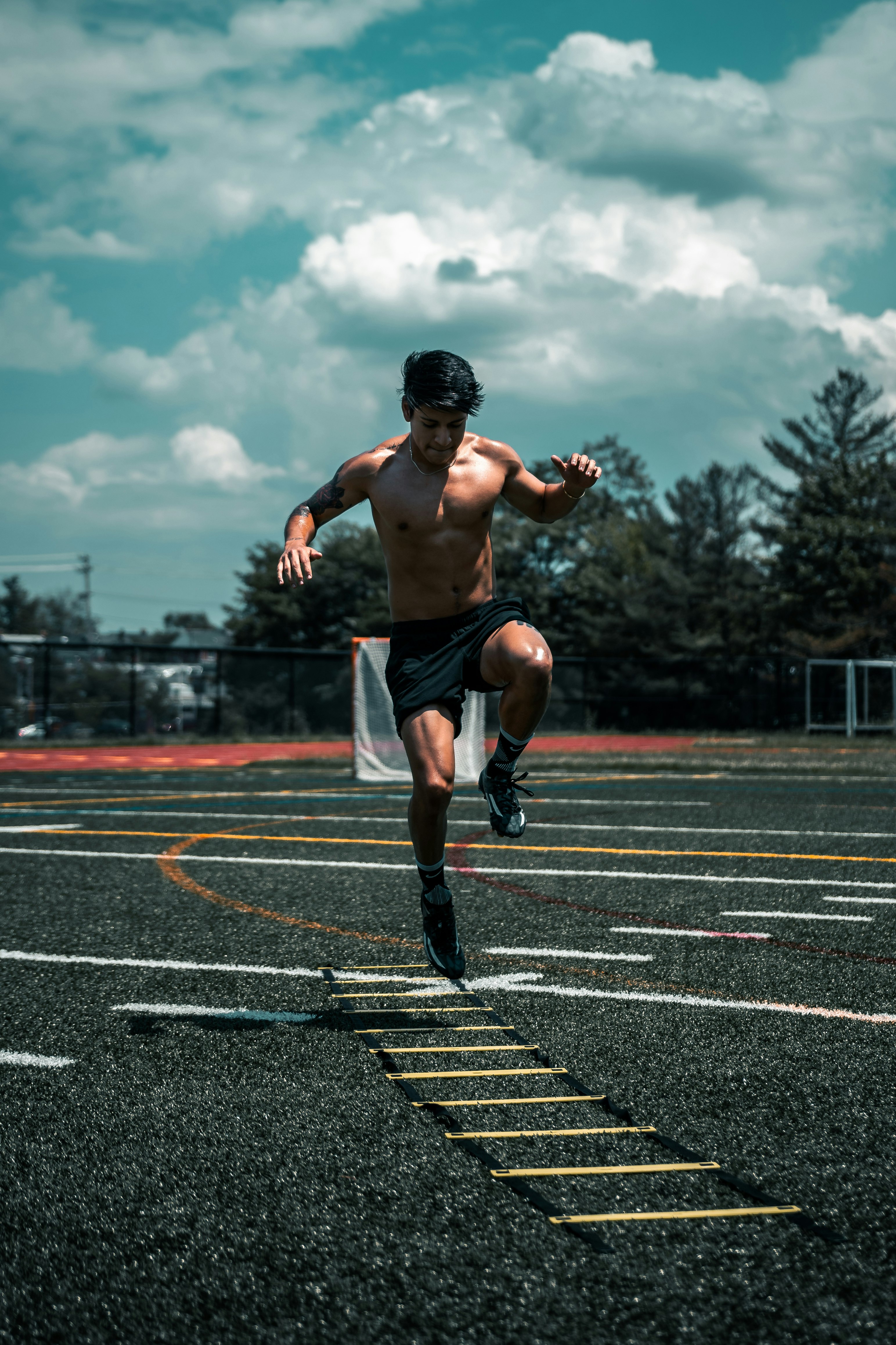 man in black shorts running on track field during daytime